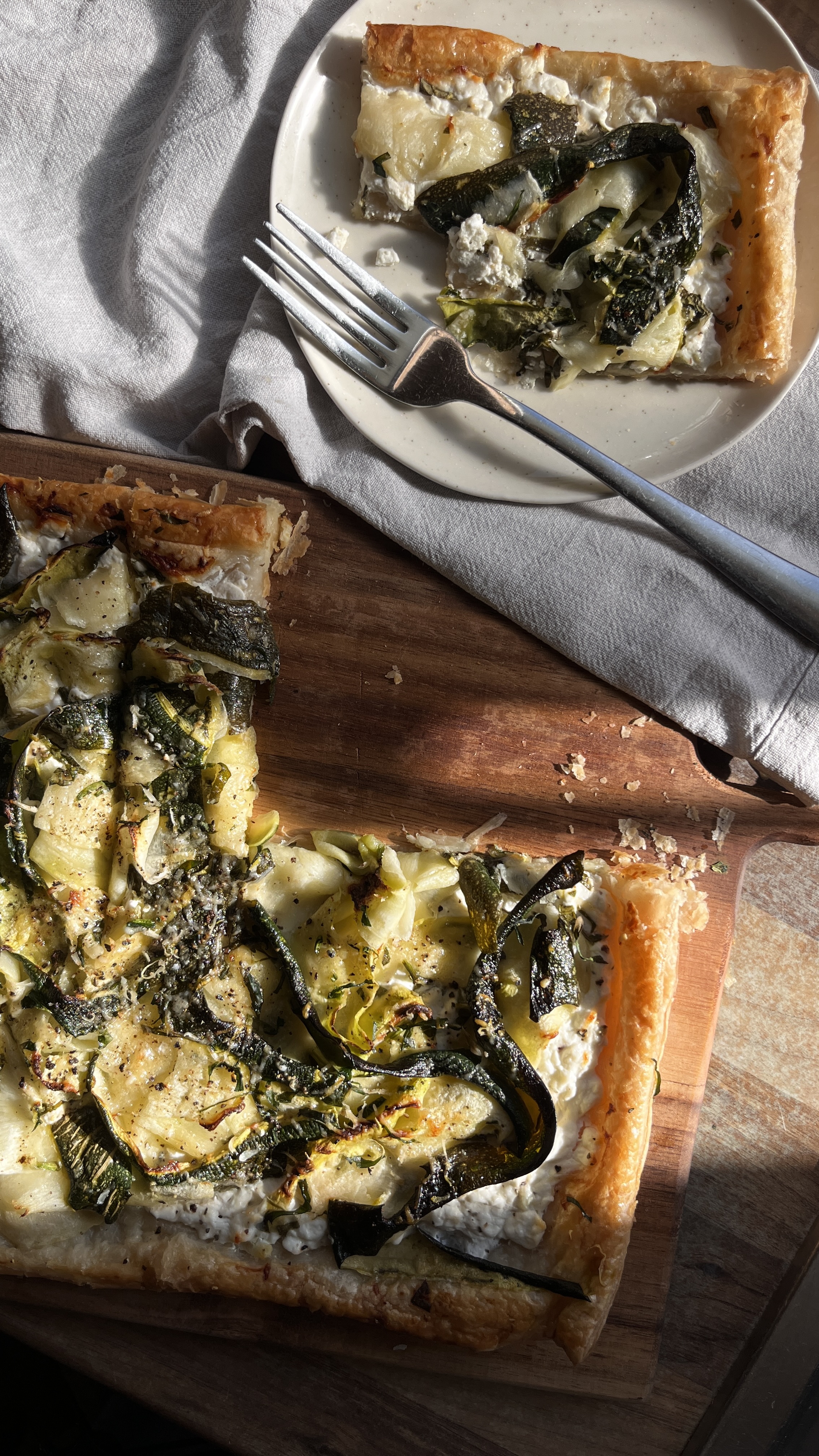Vegetarian puff pastry tart with courgette ribbons, cottage cheese, spinach, and grated hard cheese.